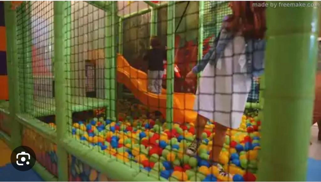 un enfant jouant dans une salle de jeux avec des jouets dans l'établissement CASA MAJOR Hotel & Appartamenti CERVIA, à Cervia