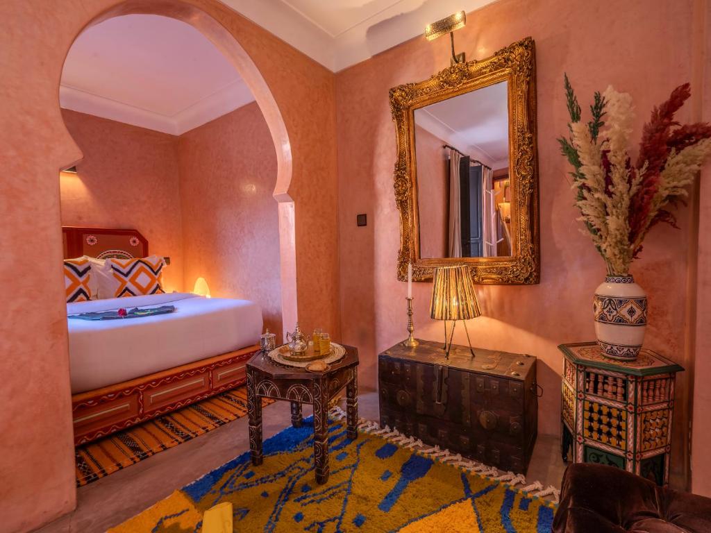 une chambre avec un lit, un miroir et une table dans l'établissement Riad Irhalne, à Marrakech 37 autres photos