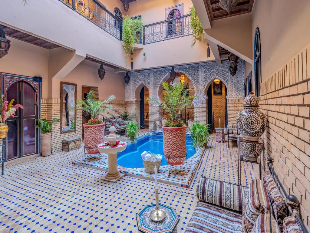 une cour avec une piscine dans une maison dans l'établissement Riad Irhalne, à Marrakech