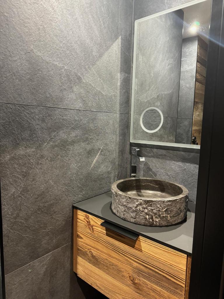 une salle de bain avec un lavabo en pierre et un miroir dans l'établissement TIGNES - VAL D'ISERE - SKI au PIED, à Tignes