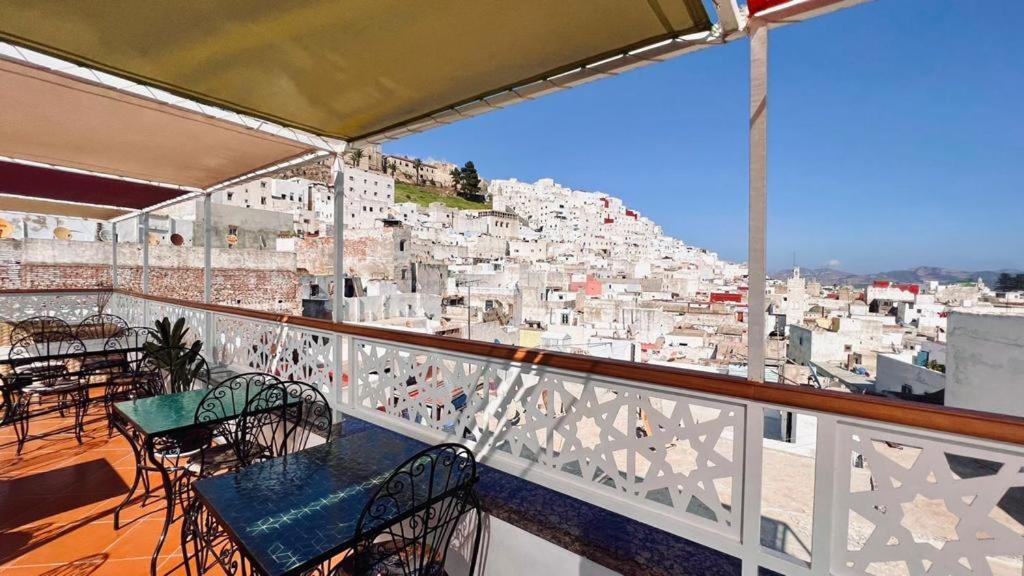 un balcon avec tables et chaises et vue sur la ville dans l'établissement Riad Amelia - Lalla Amelia Room, à Tetouan 9 autres photos