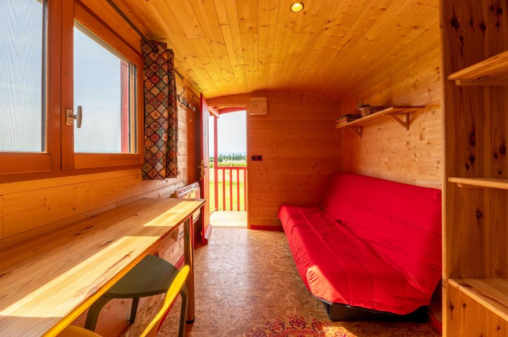 une petite chambre avec un canapé rouge dans une cabine dans l'établissement Domaine de la Cambre, à Duffort