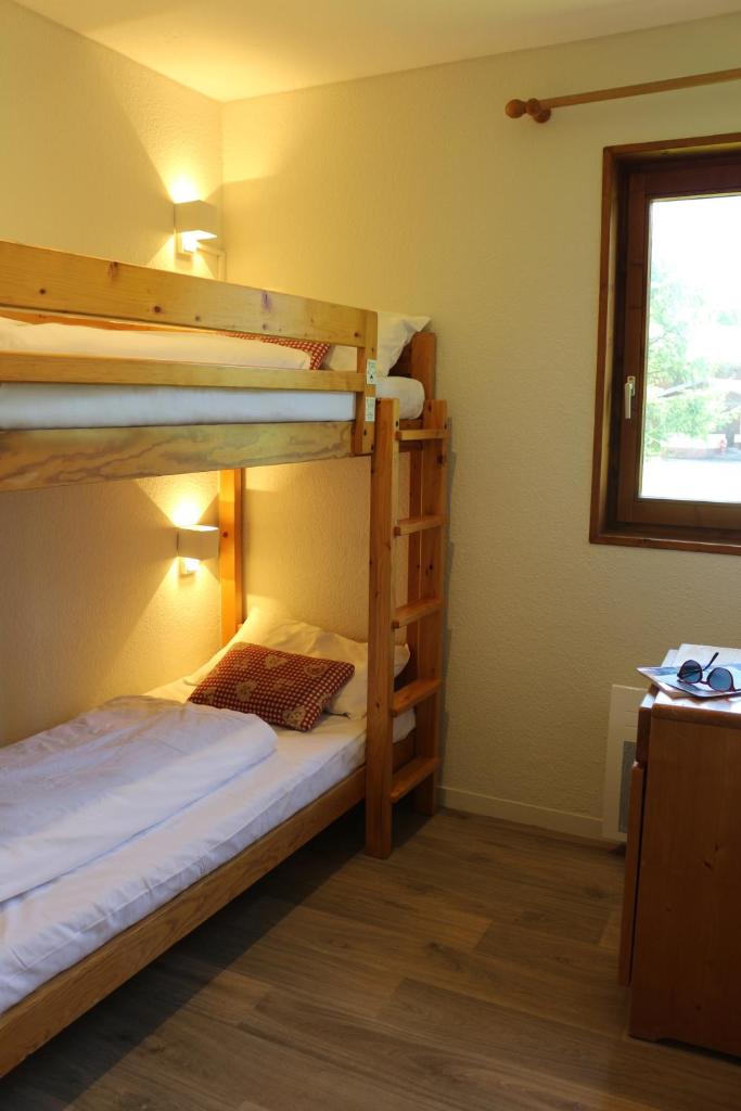 une chambre avec deux lits superposés et une fenêtre dans l'établissement Azureva La Clusaz les Aravis, à La Clusaz