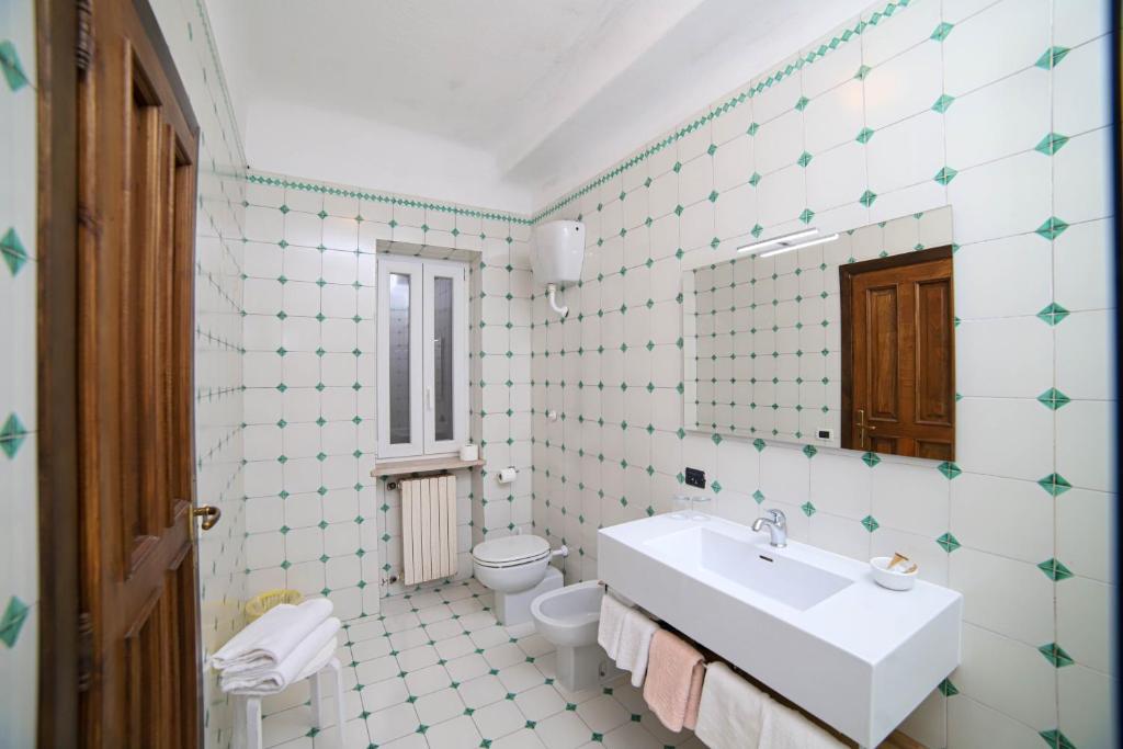 une salle de bain avec des toilettes blanches et un lavabo dans l'établissement Sweetposeidon, à Ischia