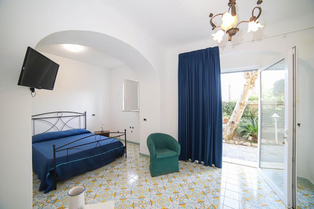 une chambre avec un lit, une télévision et une chaise dans l'établissement Sweetposeidon, à Ischia