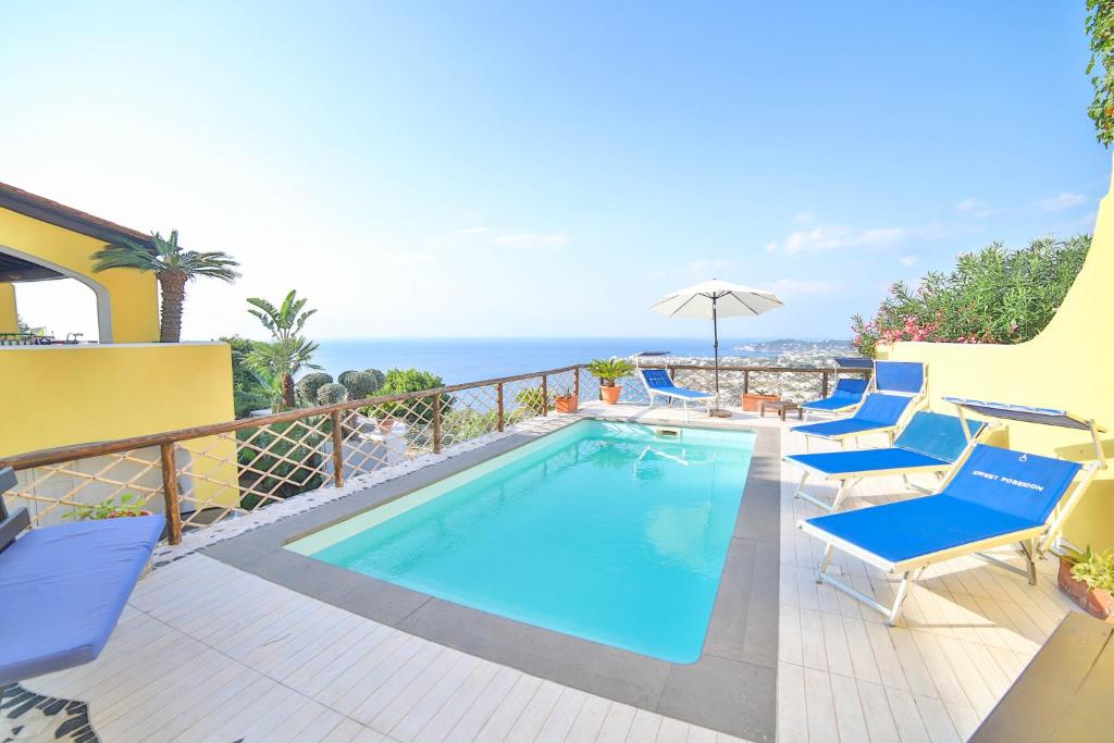 - une piscine sur un balcon avec des chaises et un parasol dans l'établissement Sweetposeidon, à Ischia