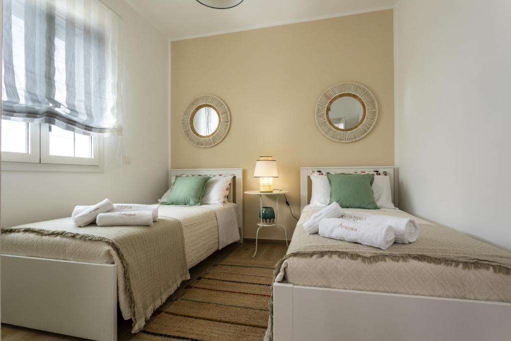 - 2 lits dans une chambre blanche avec 2 miroirs dans l'établissement Villa Amugea - IsulaTravel, à Ispica