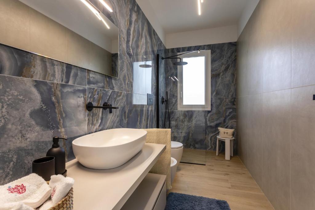 une salle de bain avec un lavabo blanc et des toilettes dans l'établissement Villa Amugea - IsulaTravel, à Ispica