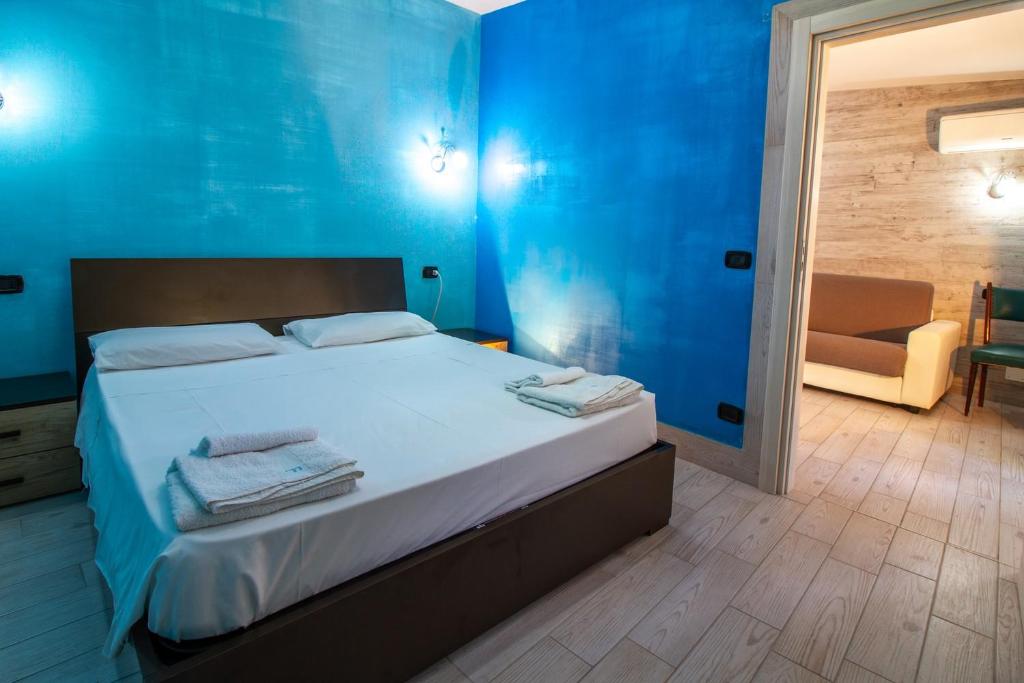 une chambre avec un lit aux murs bleus et une chaise dans l'établissement Il Posto, à Pulsano