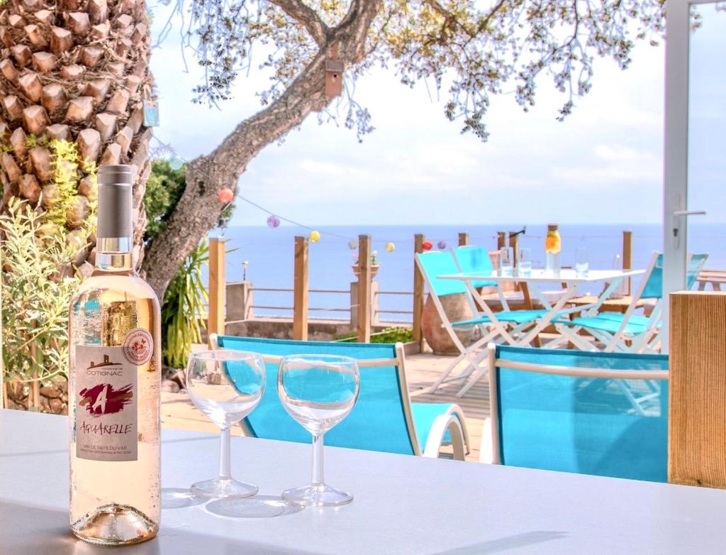 une bouteille de vin posée sur une table avec deux verres dans l'établissement Paradis bleu et ile d'or, à Saint-Raphaël