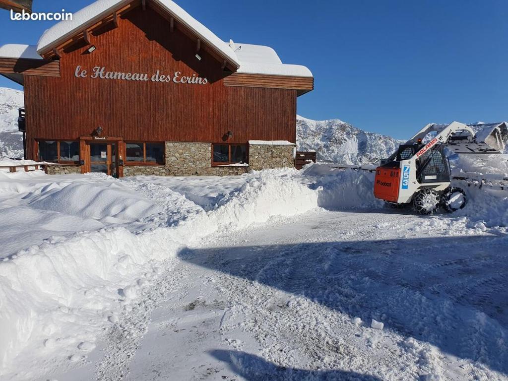 un camion de déneigement garé devant un bâtiment dans l'établissement PUY SAINT VINCENT APPARTEMENT T2 BALCON SUPER PANORAMA AVEC PARKING PRIVE COUVERT et PISCINE L'ETE, à Puy-Saint-Vincent