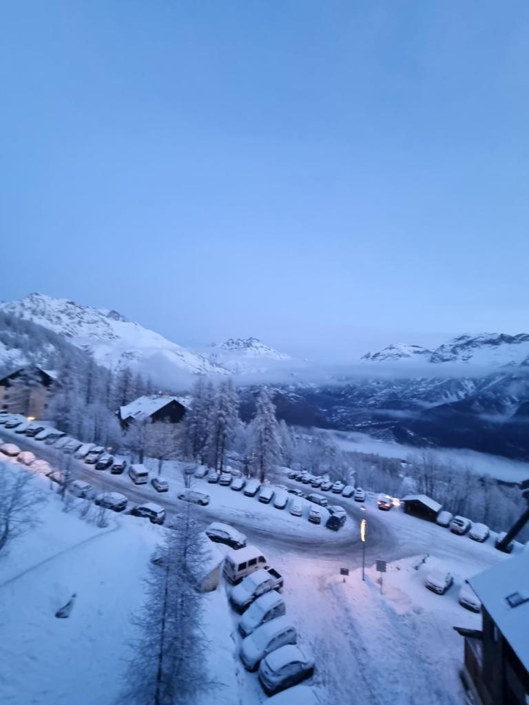 un parking couvert de neige avec des voitures garées dans l'établissement PUY SAINT VINCENT APPARTEMENT T2 BALCON SUPER PANORAMA AVEC PARKING PRIVE COUVERT et PISCINE L'ETE, à Puy-Saint-Vincent 37 autres photos