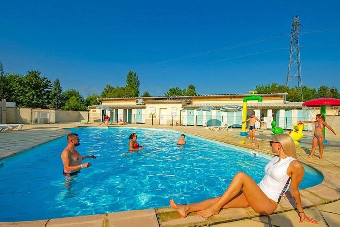 un groupe de personnes assises dans une piscine dans l'établissement Le Muscat, à Boofzheim