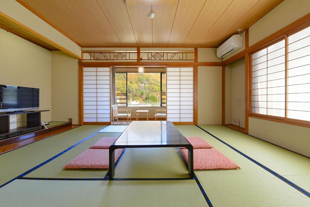 un salon avec une table en verre au milieu dans l'établissement Ooedo Onsen Monogatari Shinshu Kakeyu, à Ueda