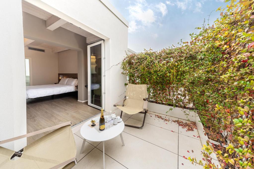 Il comprend une chambre et un balcon doté d'une table et de chaises blanches. dans l'établissement Open Hotel, à Rimini