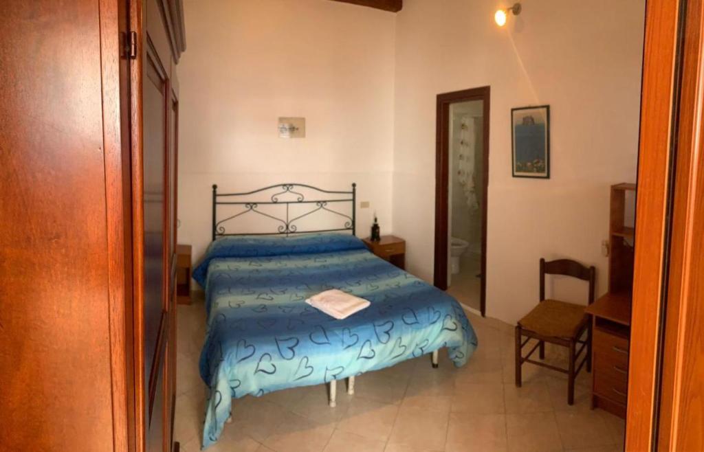 une chambre avec un lit avec une couette bleue dans l'établissement Case La Pergola, à Stromboli
