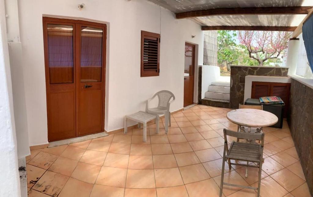 un salon avec une table et des chaises et une cheminée dans l'établissement Case La Pergola, à Stromboli