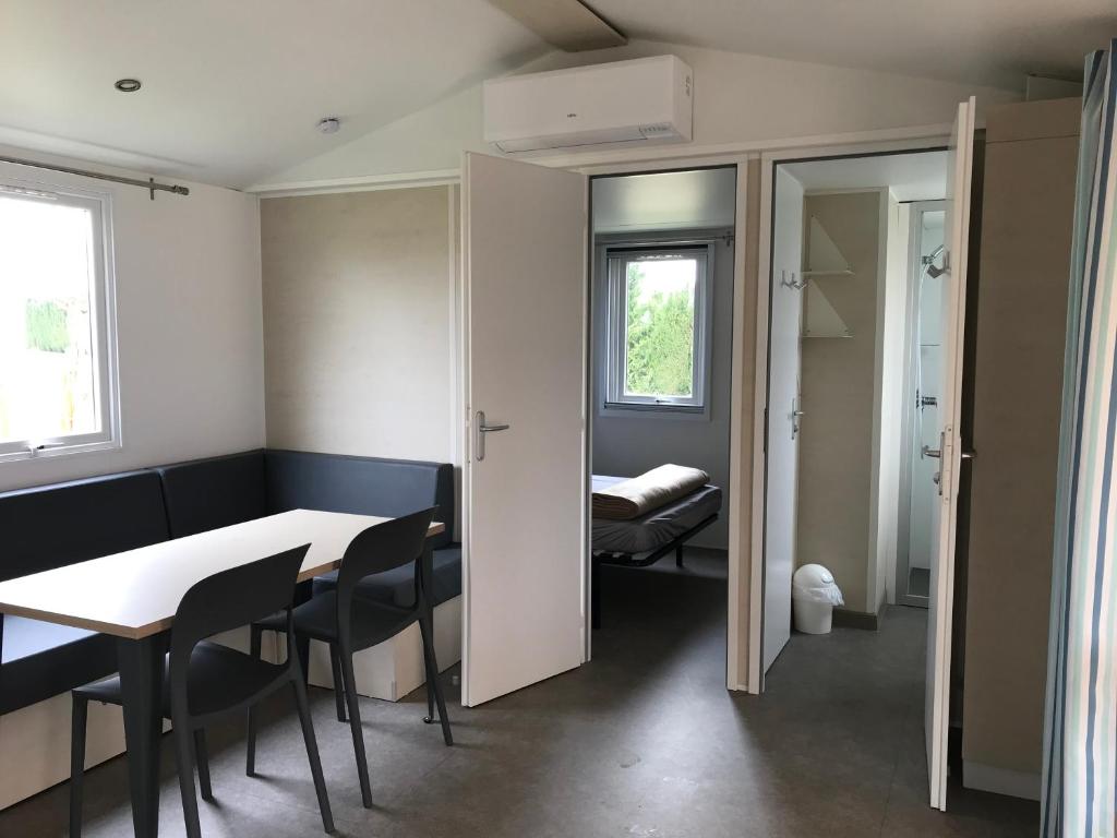 une pièce avec une table et des chaises et une chambre dans l'établissement Camping des Favards, à Violès