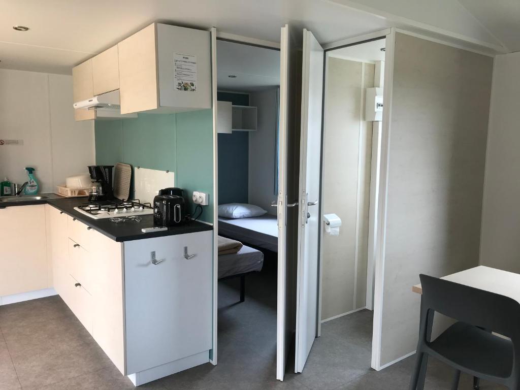 une petite cuisine avec un comptoir et une chambre dans l'établissement Camping des Favards, à Violès