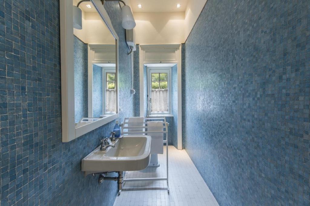 une salle de bain avec un lavabo et un miroir dans l'établissement Villa Angela, à Stresa