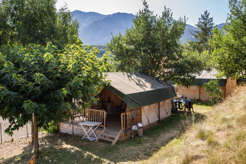une tente avec une table et des chaises dans un champ dans l'établissement Camping le Rotja, à Fuilla