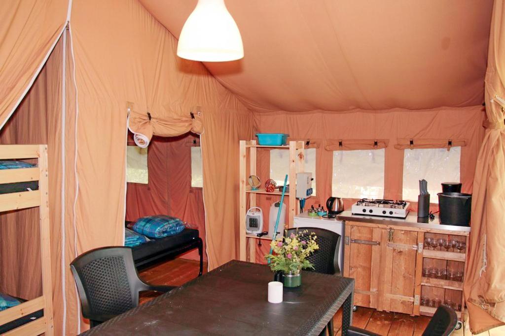 une chambre avec une table et une cuisine dans une tente dans l'établissement Camping le Rotja, à Fuilla