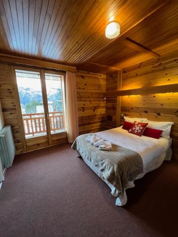 une chambre avec un lit dans une cabane en bois dans l'établissement Hôtel Restaurant La Pendine, à Puy-Saint-Vincent