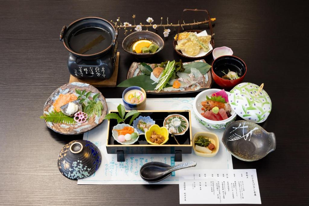 une table recouverte de bols et de plats dans l'établissement Shirahama Onsen Kisyu Hanto, à Shirahama 37 autres photos
