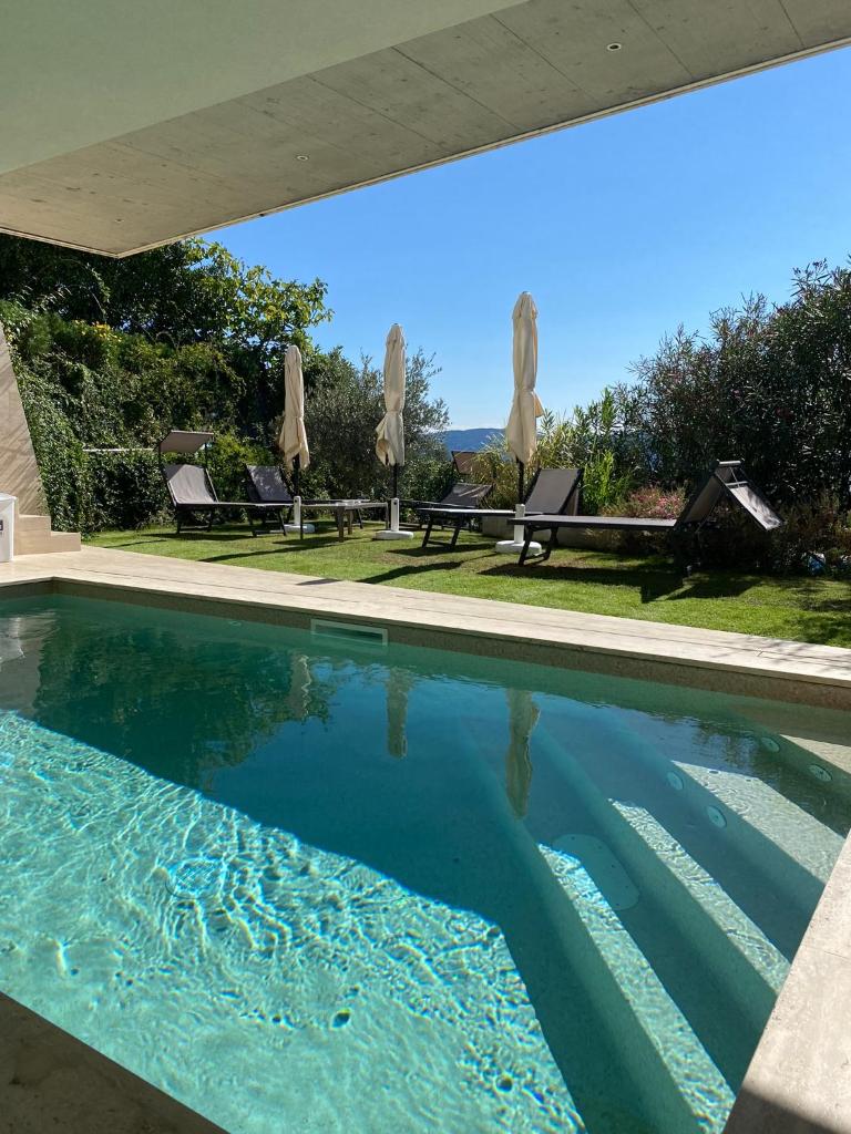 une piscine avec de l'eau bleue dans une maison dans l'établissement Villa Diamante del Garda & Spa, à Toscolano Maderno