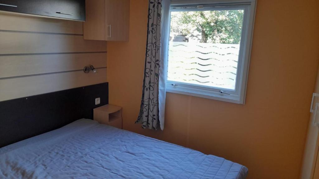 une chambre avec un lit et une fenêtre dans l'établissement Mobil home sur Carnac, à Carnac 5 autres photos