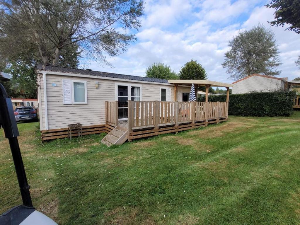 une petite maison avec un porche et une terrasse dans l'établissement Grand MobilHome, à Houlgate
