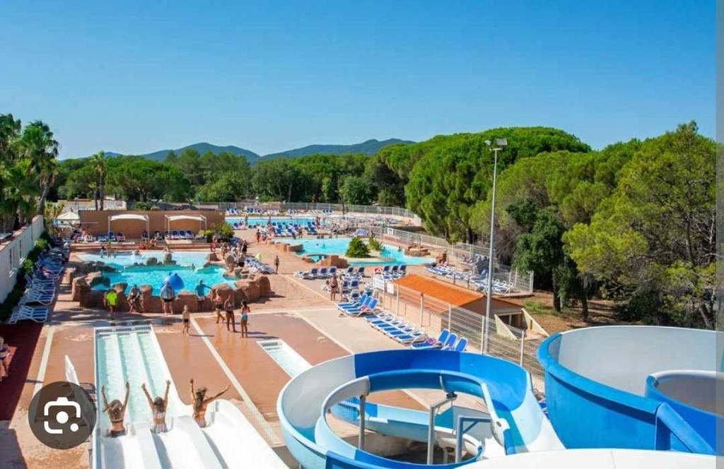 - une grande piscine avec des personnes séjournant dans un complexe dans l'établissement Mobil home Oasis Village 5*, à Puget-sur Argens