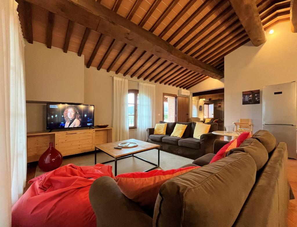 un salon avec un canapé et une télévision dans l'établissement Panoramic Villa Ludovica with private pool - Borgo del Silenzio, à Orciatico