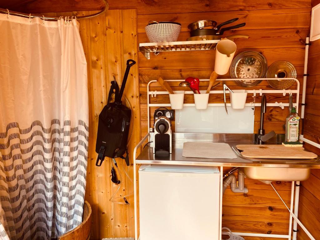une cuisine avec un comptoir et un évier dans une pièce dans l'établissement Yourte et son bain nordique, à Fréchet-Aure