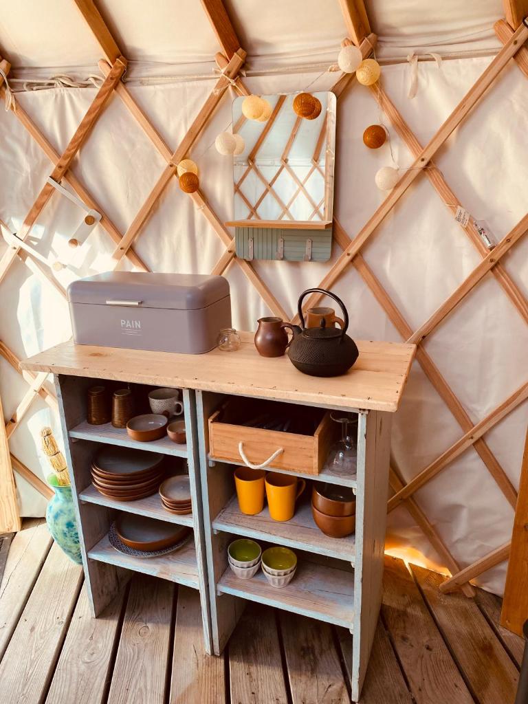 une étagère en bois dans une yourte avec une table dans l'établissement Yourte et son bain nordique, à Fréchet-Aure