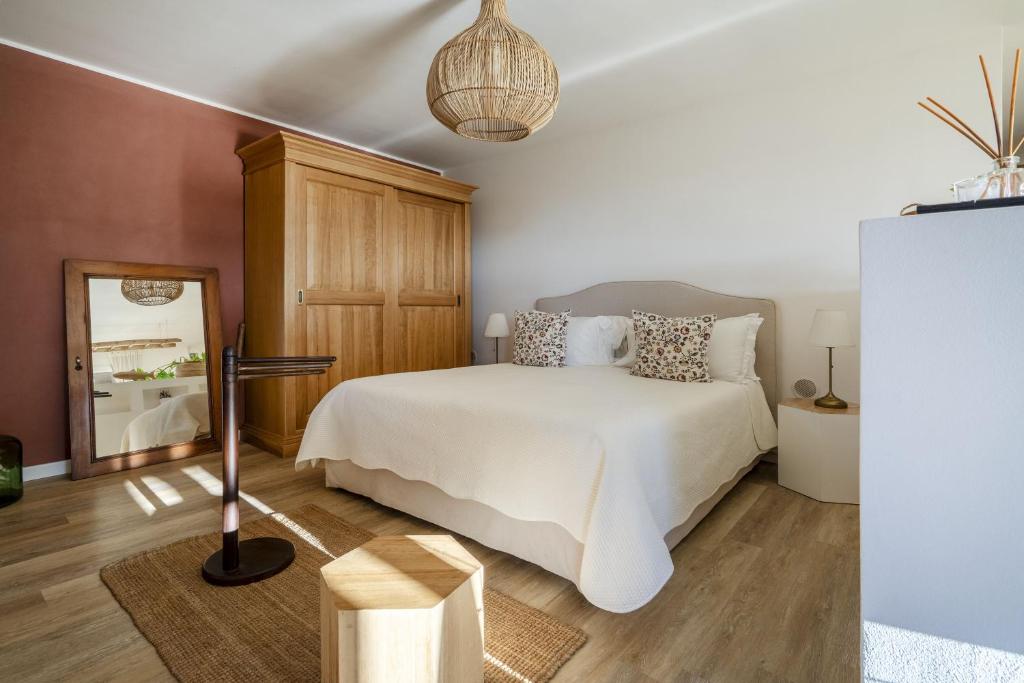 une chambre avec un lit blanc et un miroir dans l'établissement Villa Torto with private pool, à Monopoli