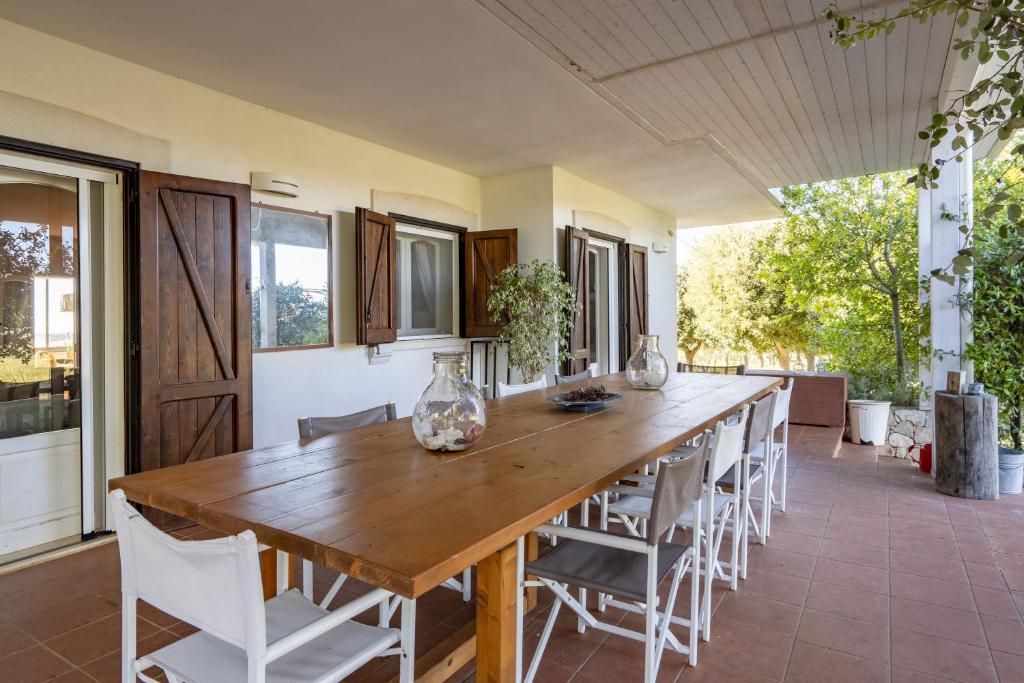 une salle à manger avec une grande table et des chaises en bois dans l'établissement Villa Torto with private pool, à Monopoli
