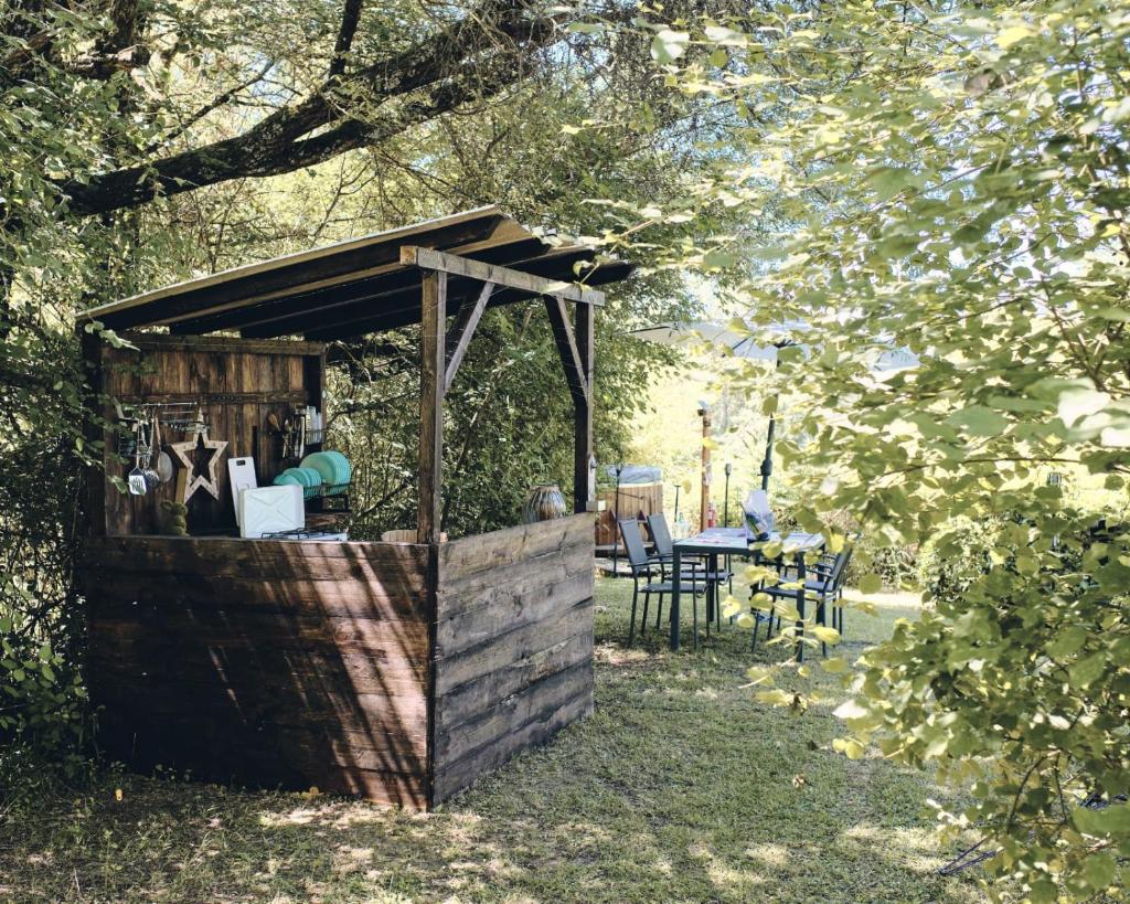 un hangar en bois avec une table dans la cour dans l'établissement Camping d'Artagnan, à Margouët-Meymès