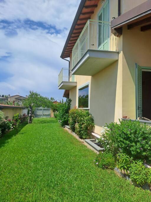 une maison avec une cour verdoyante devant elle dans l'établissement Villa SouAri 10' da Forte de Marmi - 2km spiaggia, à Lido di Camaiore