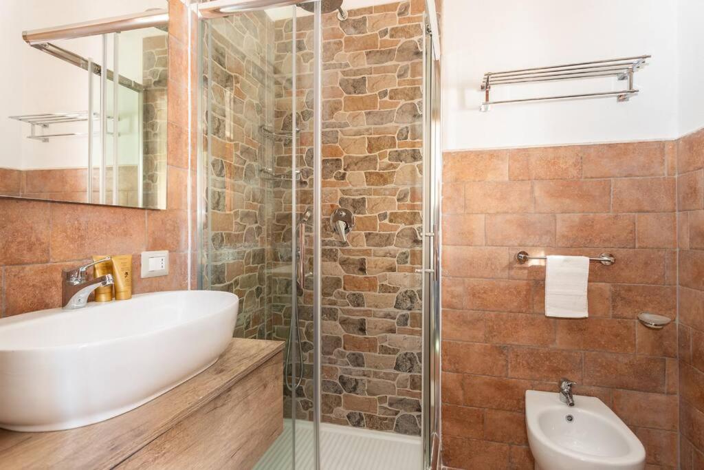 une salle de bain avec un lavabo et une douche en verre dans l'établissement Villa Carla - Frontsea house with private pool and sauna, à Costa Paradiso