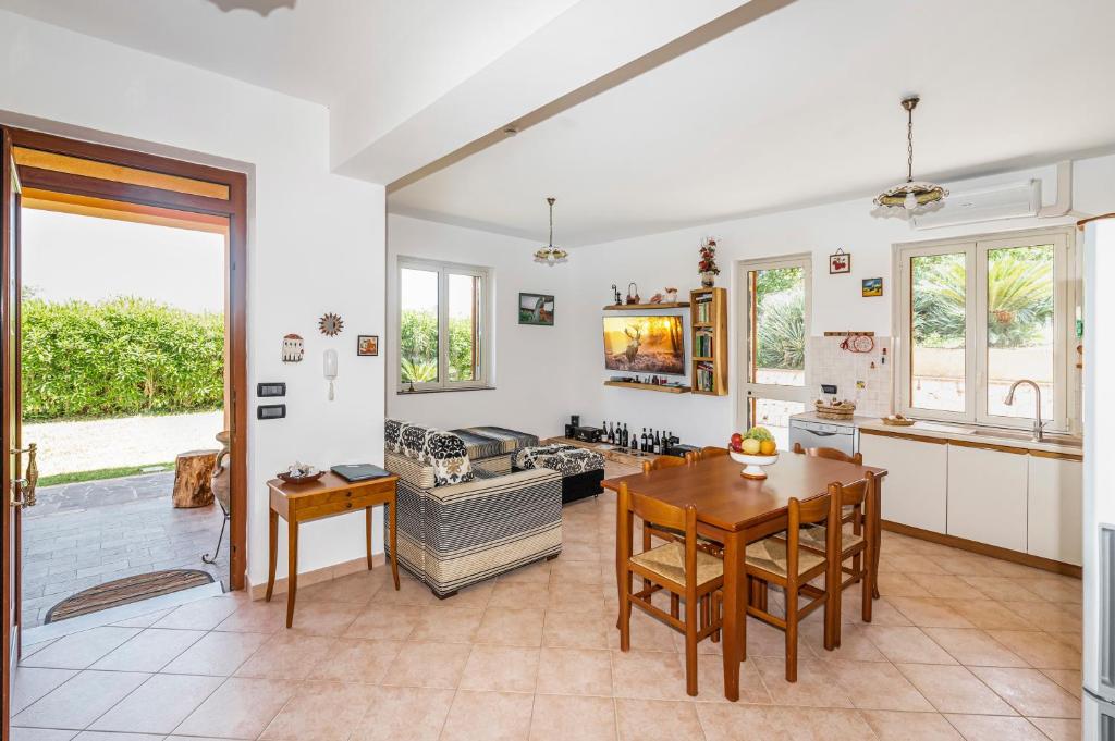 une cuisine et un salon avec une table et des chaises dans l'établissement Delightful 4 Bed Villa with Heated pool & Jacuzzi Overlooking Aeolian Islands, à Castroreale