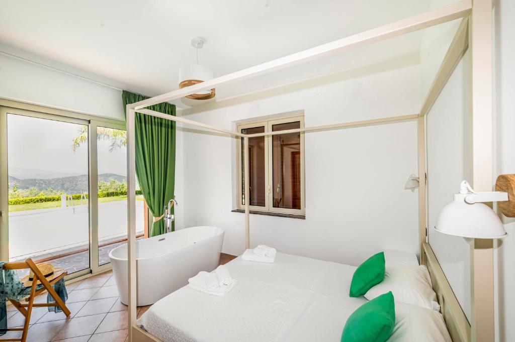 - une chambre avec une baignoire, un lit et une fenêtre dans l'établissement Delightful 4 Bed Villa with Heated pool & Jacuzzi Overlooking Aeolian Islands, à Castroreale