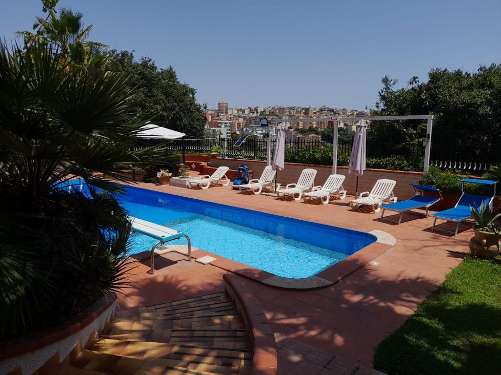 une piscine avec des chaises longues et une piscine dans l'établissement Villa Aladin, à Sciacca