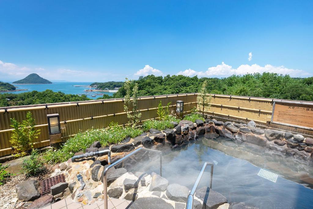 - une grande piscine avec des rochers et de l'eau dans l'établissement Ooedo Onsen Monogatari Amakusa Hotel Kameya, à Kami Amakusa