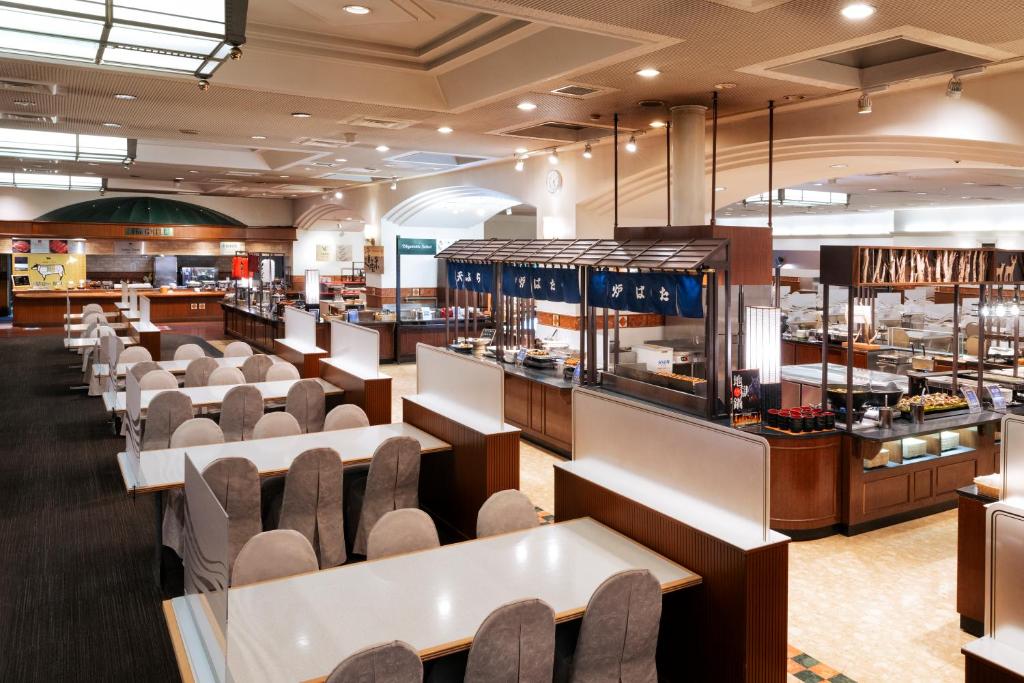 un restaurant avec des tables et des chaises et une cafétéria dans l'établissement Noboribetsu Grand Hotel, à Noboribetsu