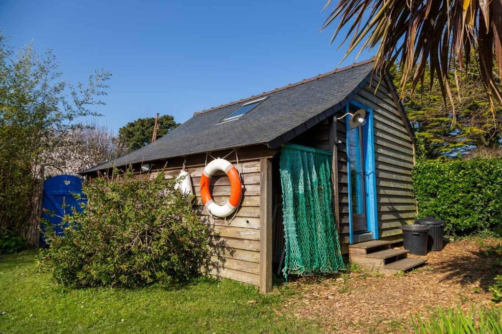 une petite maison avec un préservateur de la vie orange. dans l'établissement La Quille en l'air, à Crozon