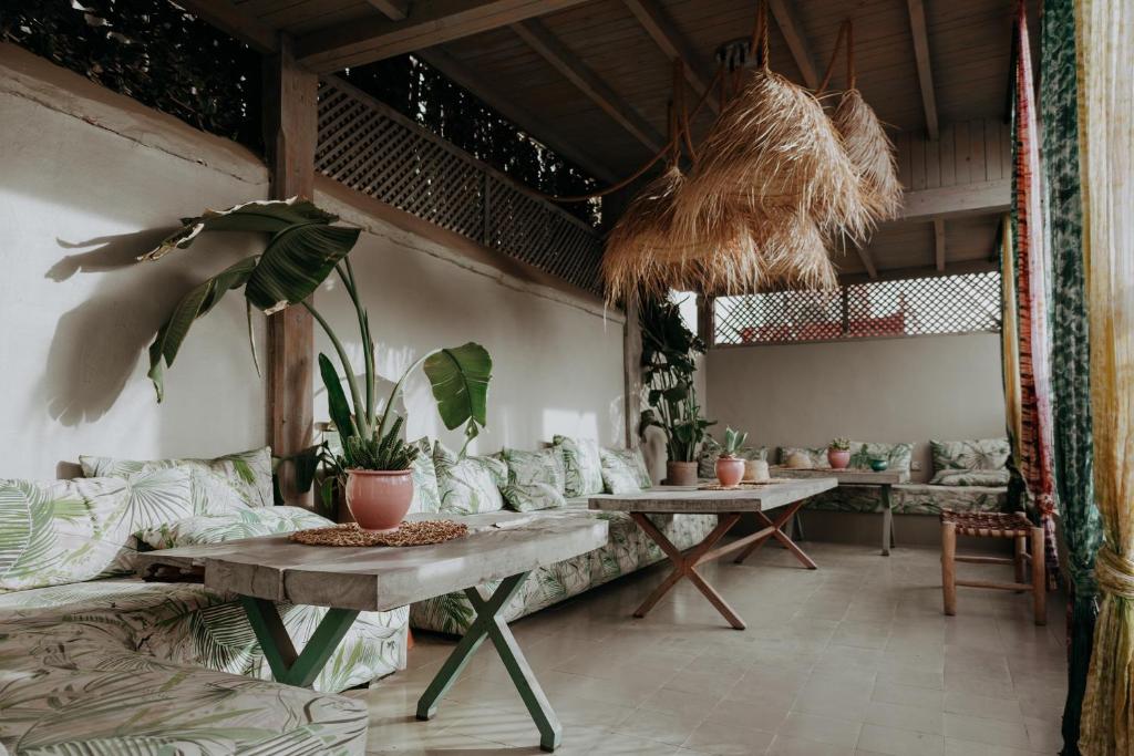 un salon avec un canapé, des tables et des plantes dans l'établissement Riad 117, à Marrakech