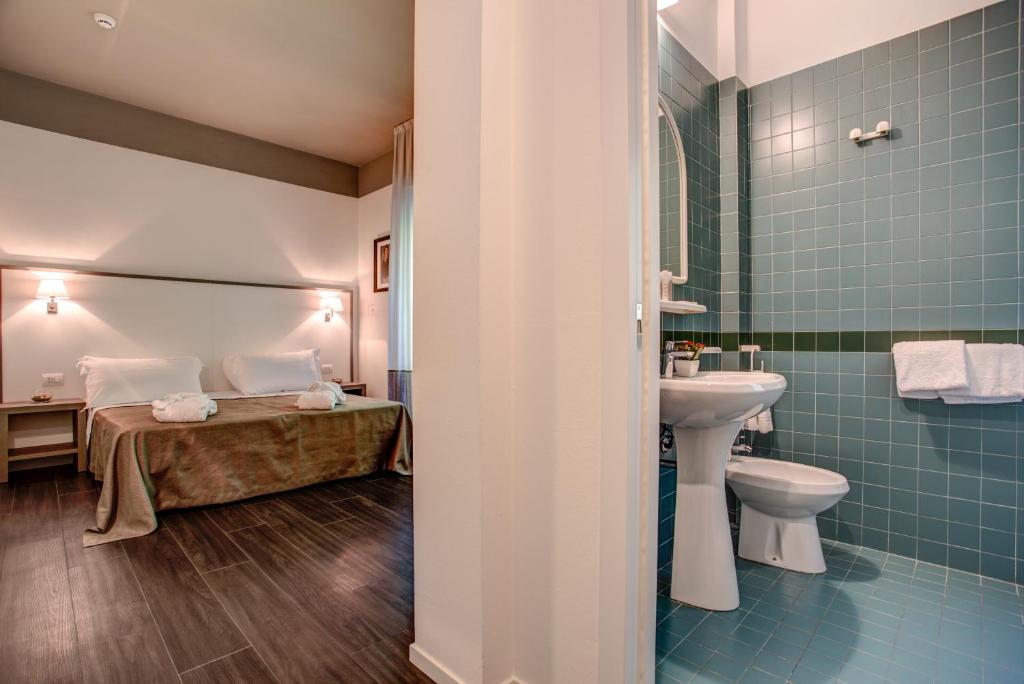 une salle de bain avec un lit, un lavabo et des toilettes dans l'établissement Hotel Cristallo, à Cattolica