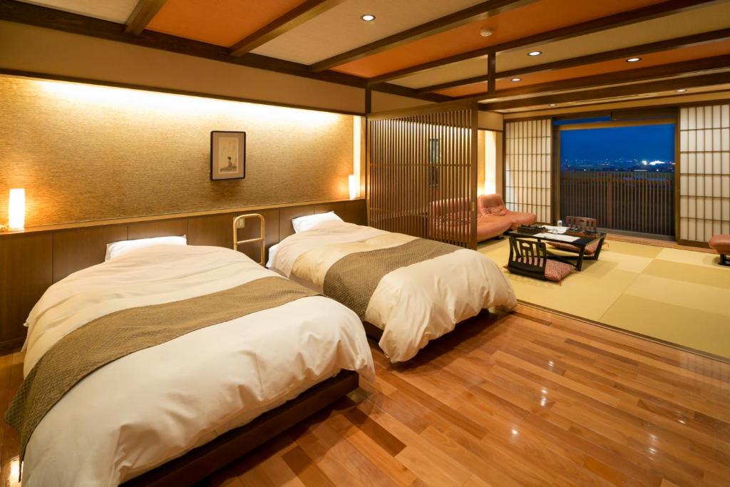 une chambre avec deux lits et un salon dans l'établissement Roppokan, à Asakura