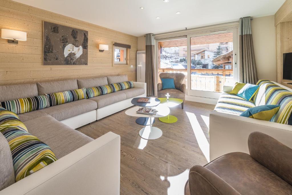 un salon avec un canapé et une table dans l'établissement Les Chalets Du Jardin Alpin, à Val dʼIsère